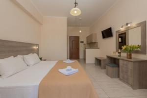a bedroom with a large bed and a kitchen at Costas Studios in Argassi