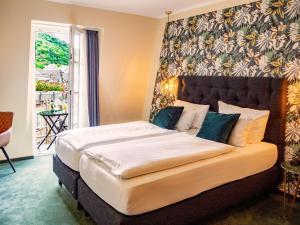 a bedroom with a large bed with a large headboard at Hotel Germania in Cochem