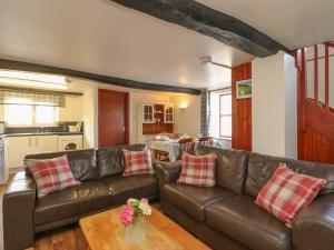 a living room with a leather couch and a table at The Stable in Bude