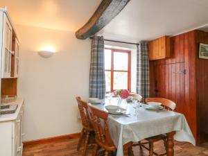 a kitchen with a table with chairs and a window at The Stable in Bude +19 photos