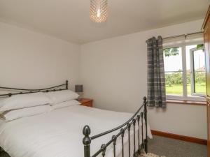 a bedroom with a bed and a window at The Stable in Bude