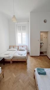 a bedroom with two beds and a wooden floor at Synagogue View Guest House in Budapest