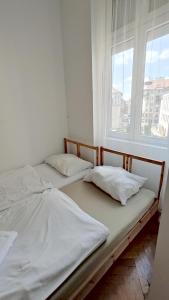 two twin beds in a room with a window at Synagogue View Guest House in Budapest