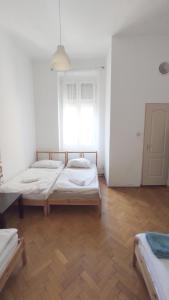 two beds in a white room with a window at Synagogue View Guest House in Budapest