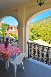 a patio with a table and chairs on a balcony at Yannis - Holiday Apartments on Agios Gordios Beach in Corfu in Agios Gordios