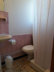 a bathroom with a toilet and a sink at Acacias Hôtel Motel in Vendays-Montalivet