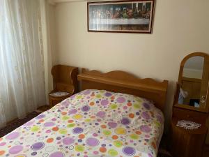1 dormitorio con cama con colcha de lunares en Apartament Aqua en Călimăneşti