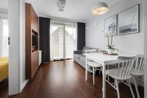 a living room with a white table and chairs at Apartamenty Paliki in Jastrzębia Góra