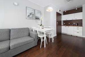 a living room with a couch and a table at Apartamenty Paliki in Jastrzębia Góra