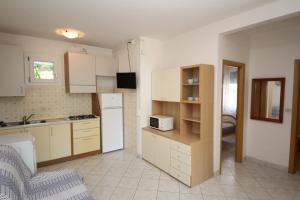 eine Küche mit weißen Schränken und einem weißen Kühlschrank in der Unterkunft Arianna 01 in Rosolina Mare