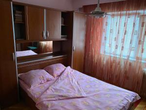 Un dormitorio pequeño con una cama y una ventana. en Apartament Aqua, en Călimăneşti