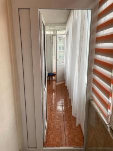 un pasillo con cortinas blancas y un pasillo con puerta en Apartament Aqua, en Călimăneşti