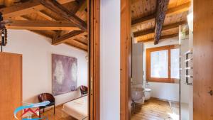 a room with wooden ceilings and a room with a mirror at Au Nom de la Rose in Venice