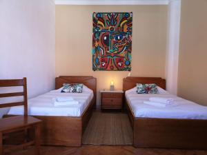 2 camas en una habitación con un cuadro en la pared en Foz Surfcamp, en Foz do Arelho