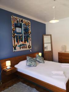 a bedroom with a bed with a painting on the wall at Foz Surfcamp in Foz do Arelho