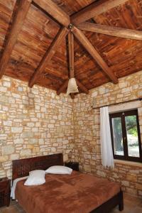 1 dormitorio con 1 cama en una pared de piedra en VILLA KOUTSOYPIA STONE HOUSE, en Sami