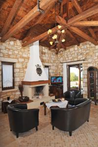 a living room with leather chairs and a fireplace at VILLA KOUTSOYPIA STONE HOUSE in Sami