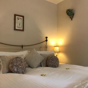 a bedroom with a white bed with pillows and a lamp at Park Farm in Windsor