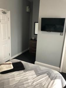a bedroom with a bed and a television at The Holystone Bar & Restaurant in Forest Hall