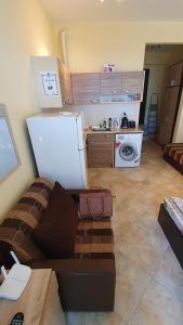 a living room with a couch and a refrigerator at Студия първа линия Черноморец in Chernomorets