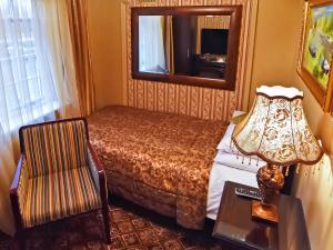 a bedroom with a bed and a mirror and a chair at Riverside Inn in Ely