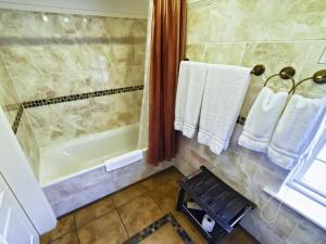 a bathroom with a shower and a tub and towels at Riverside Inn in Ely +8 photos