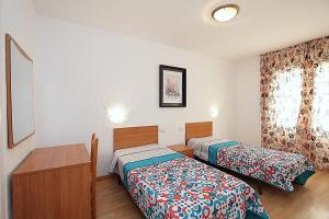 una stanza con due letti e una finestra di Apartaments Nàutic a Lloret de Mar