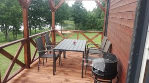 a porch with a table and chairs and a grill at B10 Pan i Pani Żuraw nad Jeziorem in Ełk