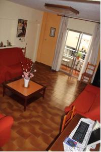 アルムニェーカルにあるHostal Andaluciaのリビングルーム(赤いソファ、テーブル付)