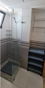 ein Bad mit einer Dusche und einer Glastür in der Unterkunft GrayAppart Kénitra in Kenitra