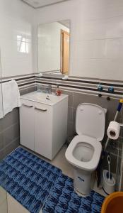 uma casa de banho com um WC branco e um piso azul em GrayAppart Kénitra em Kenitra