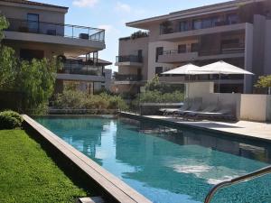 a swimming pool in front of a building at Exclusive Resort Apartments with parking , gym and sauna in Saint-Tropez