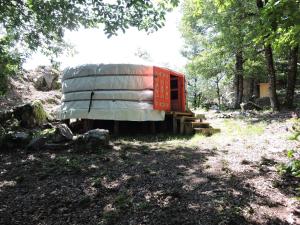 a small trailer sitting in the middle of a forest at Yourte mongole in Mont-Roc