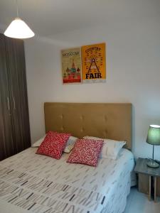 1 dormitorio con 1 cama con 2 almohadas rojas en CH3 Moderno apartamento amoblado en condominio RNT-1O8238 en Valledupar