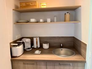 a kitchen counter with a sink and a appliance at Villa d'hôtes Graine de Pin in Le Touquet-Paris-Plage