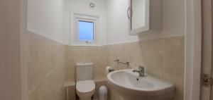 a small bathroom with a sink and a toilet at Grace Apartments - Living Stone 2 in Ashford