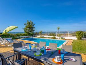 un patio avec une table et des chaises à côté d'une piscine dans l'établissement Villa Villa Blue Ocean by Interhome, à Patroves