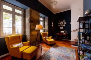 a living room with two yellow chairs and a table at My Angra Charming House in Angra do Heroísmo