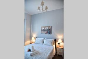 ein Schlafzimmer mit einem Bett mit einer weißen Tagesdecke in der Unterkunft Family Apartments 4 in Lékhaion