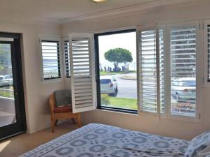 1 dormitorio con 1 cama y una ventana con persianas en Florentine 4 spectacular views and air conditioning en Nelson Bay