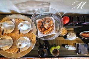 a table with a tray of pastries and a plate of food at Maison Matilda - Luxury Rooms & Breakfast in Treviso