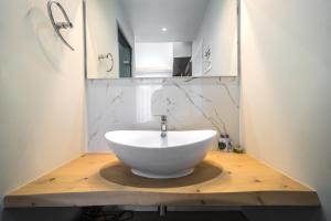 ein Badezimmer mit einem weißen Waschbecken auf einem Holztisch in der Unterkunft Porto Kalamaki Hotel in Kalamaki