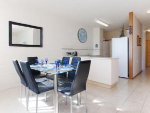 a dining room with a table and chairs and a refrigerator at Little Hut 1 Spectacular Water Views NBN and Air Conditioned in Nelson Bay +9 photos
