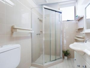 a bathroom with a shower and a toilet and a sink at Little Hut 1 Spectacular Water Views NBN and Air Conditioned in Nelson Bay