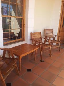 two chairs and a wooden table and two benches at Wheatlands Lodge in Bredasdorp