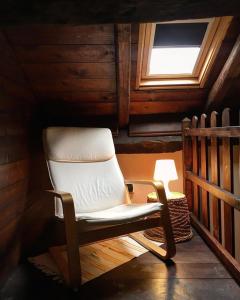 a rocking chair in a cabin with a window at Cascina Bertolotto Wine Resort in Spigno Monferrato