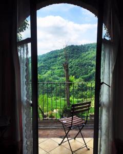 a view from a window of a chair on a porch at Cascina Bertolotto Wine Resort in Spigno Monferrato