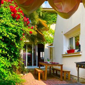 eine Terrasse mit einem Tisch und Bänken vor einem Gebäude in der Unterkunft la Maison de Lilly in Pierry