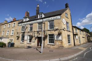 an old brick building on the corner of a street at The Kings Arms Hotel in Chipping Norton