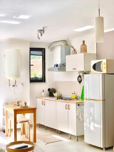 a kitchen with white cabinets and a table and a refrigerator at Quinta do Marinheiro - Meco in Aldeia do Meco +33 photos